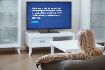 A woman looks at Disney Plus error code 39 on her TV.